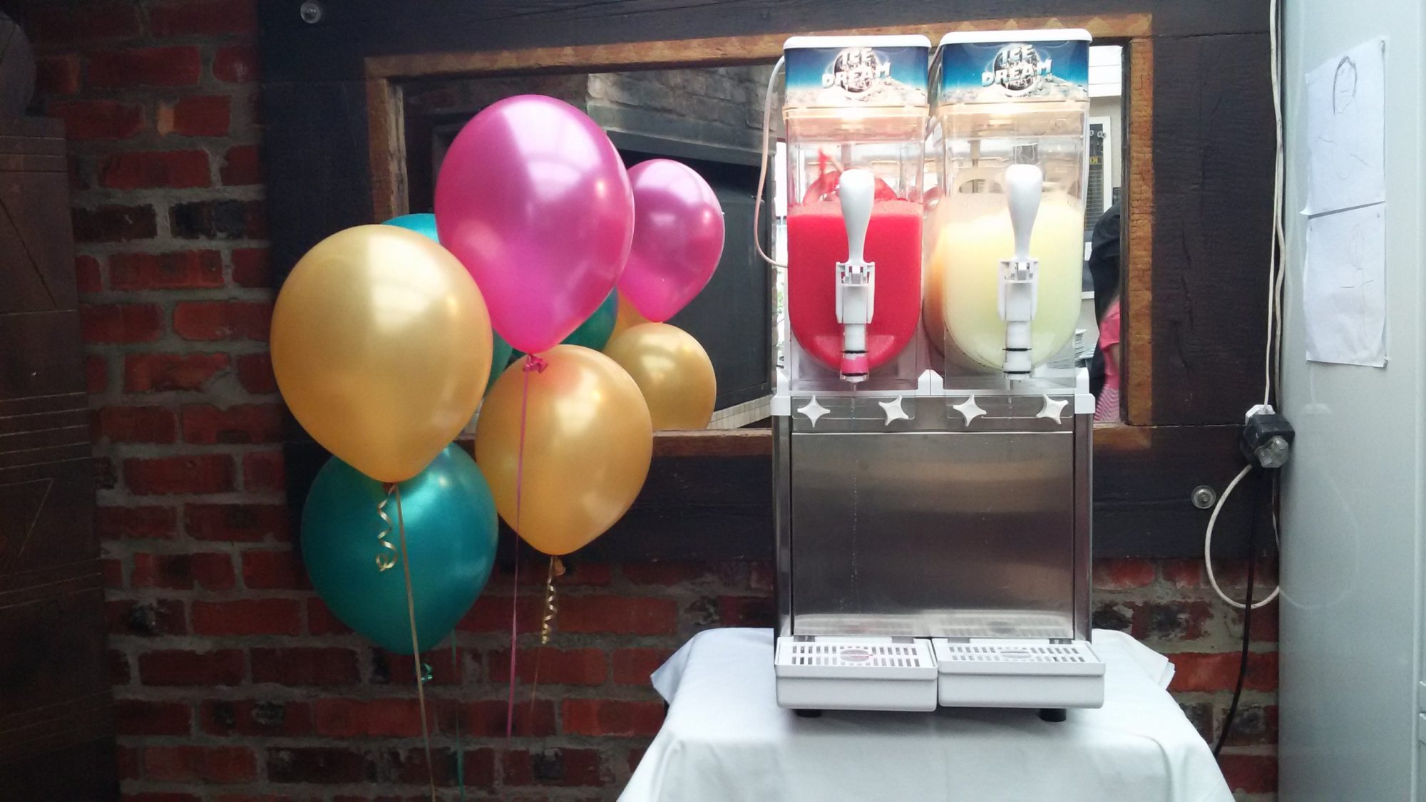 Slushie machine with colorful drinks and balloons