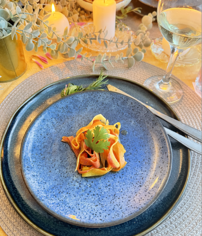 Artisan pasta dish with herbs on a blue plate