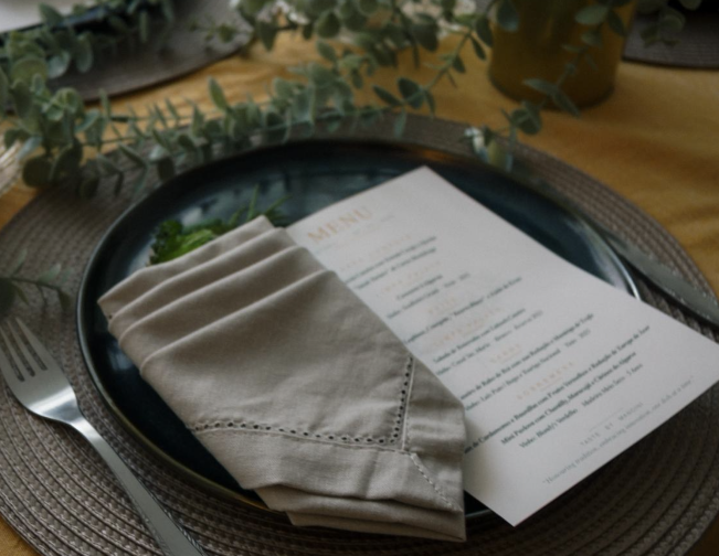 Dark plate with folded napkin and a printed menu