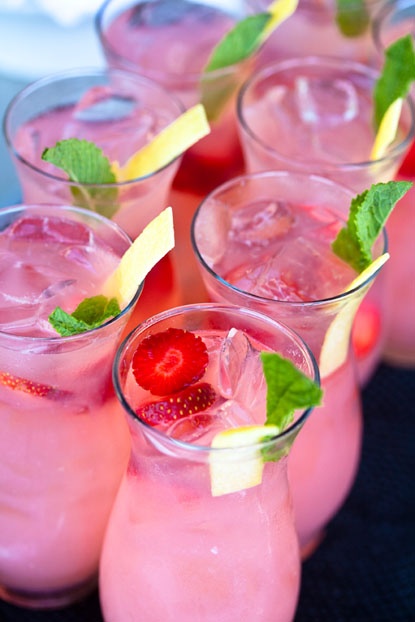 Glasses of pink drinks garnished with mint and lemon