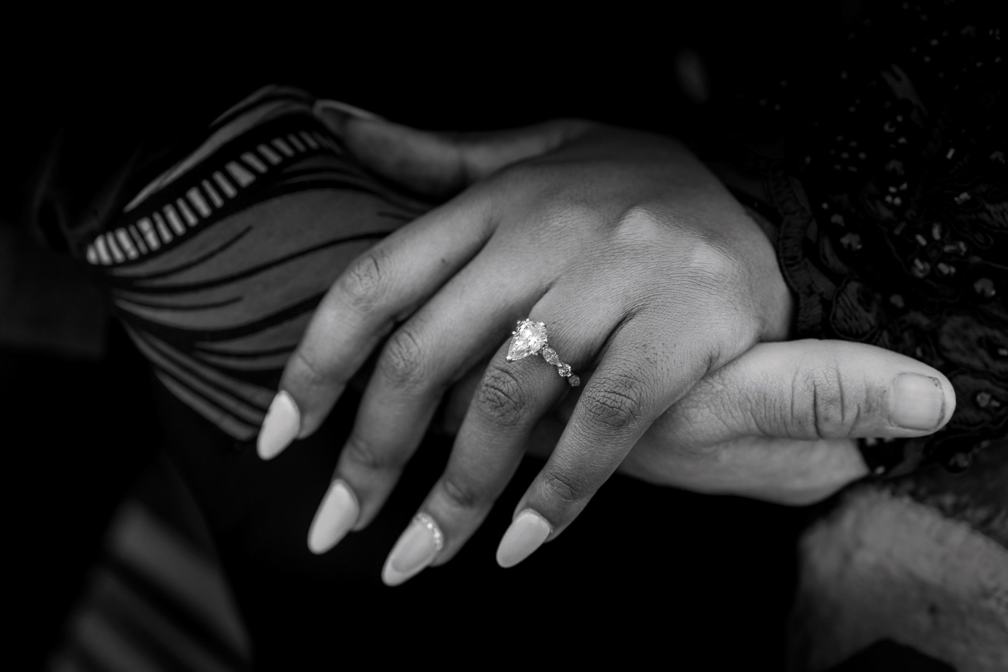 Close-up of a hand showing an engagement ring.