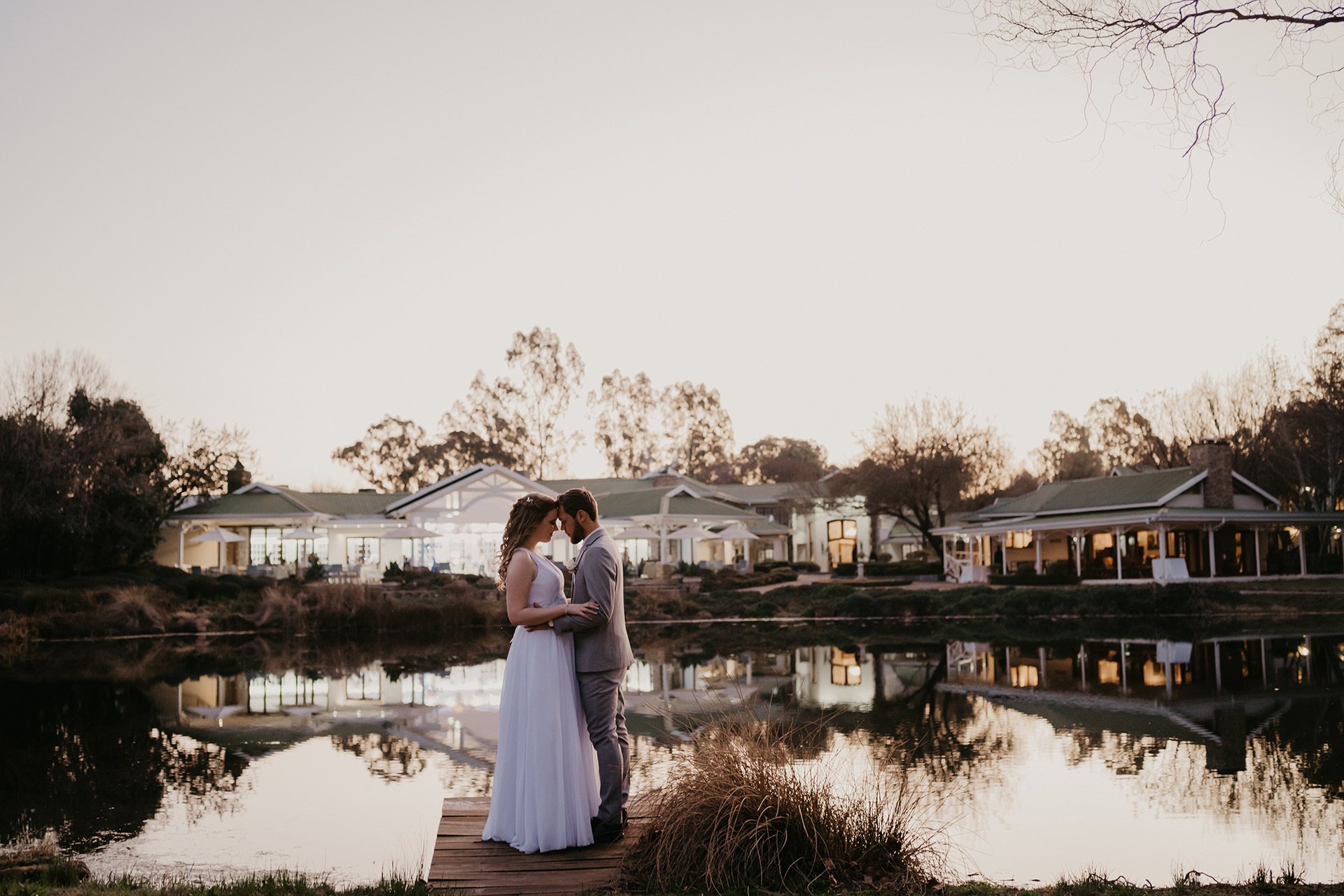 Couple embracing by a lake at sunset