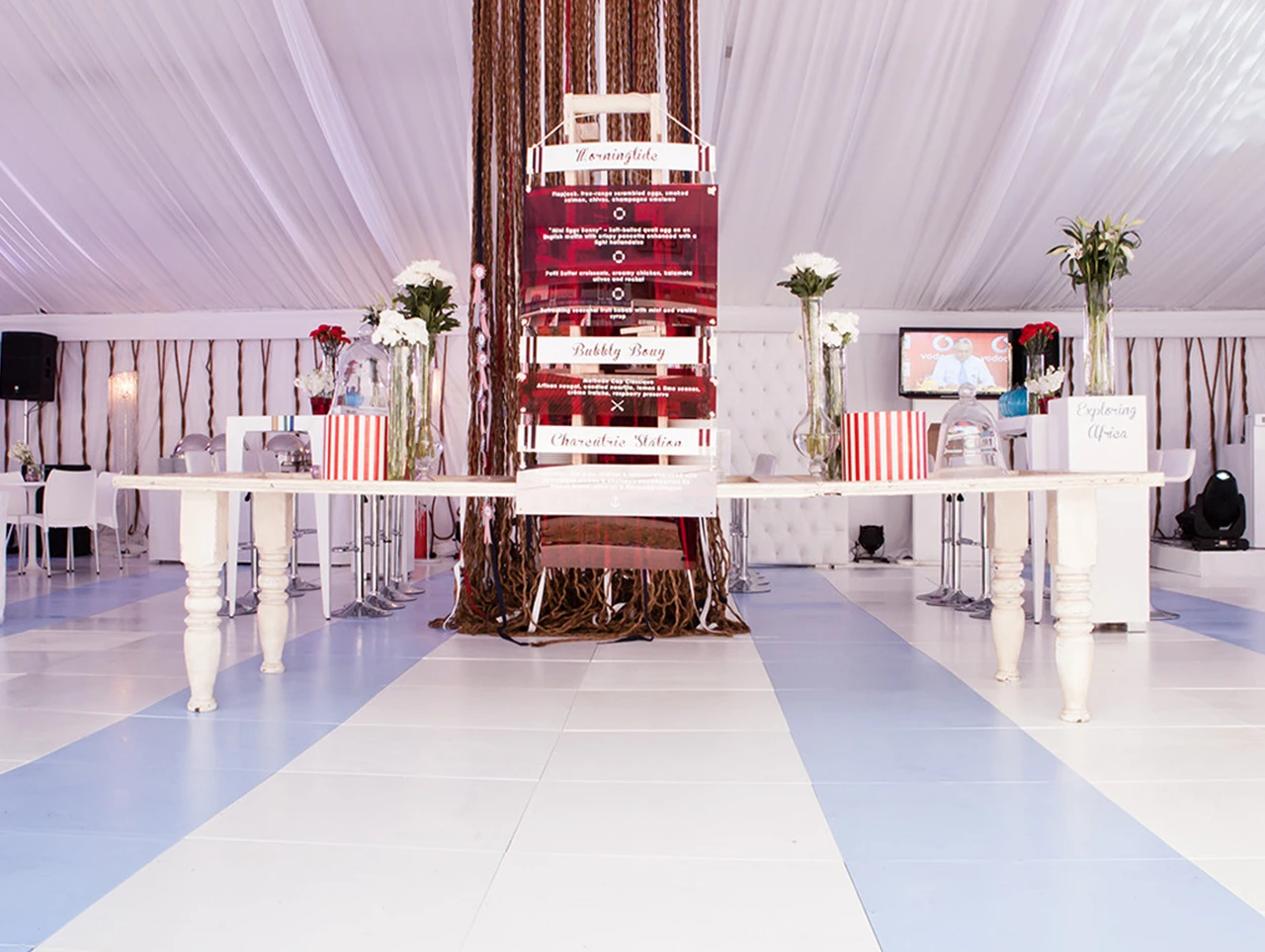 White modular dance floor with blue accents set in a tent