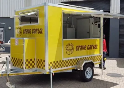 Bright yellow coffee trailer with checkered pattern
