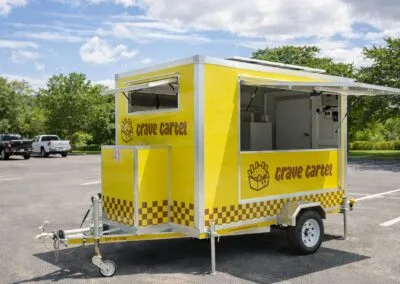 Yellow food trailer with checkerboard pattern and signage