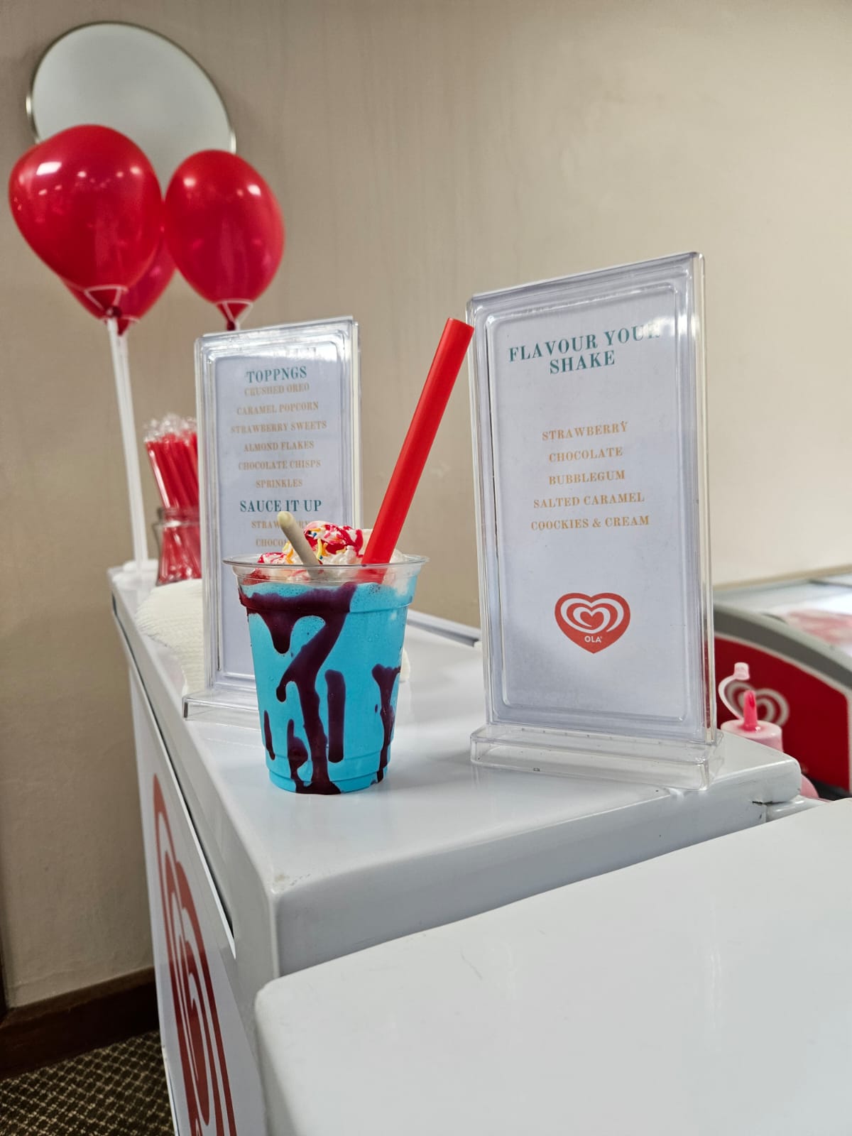 Ice cream shake with syrup and toppings on a counter
