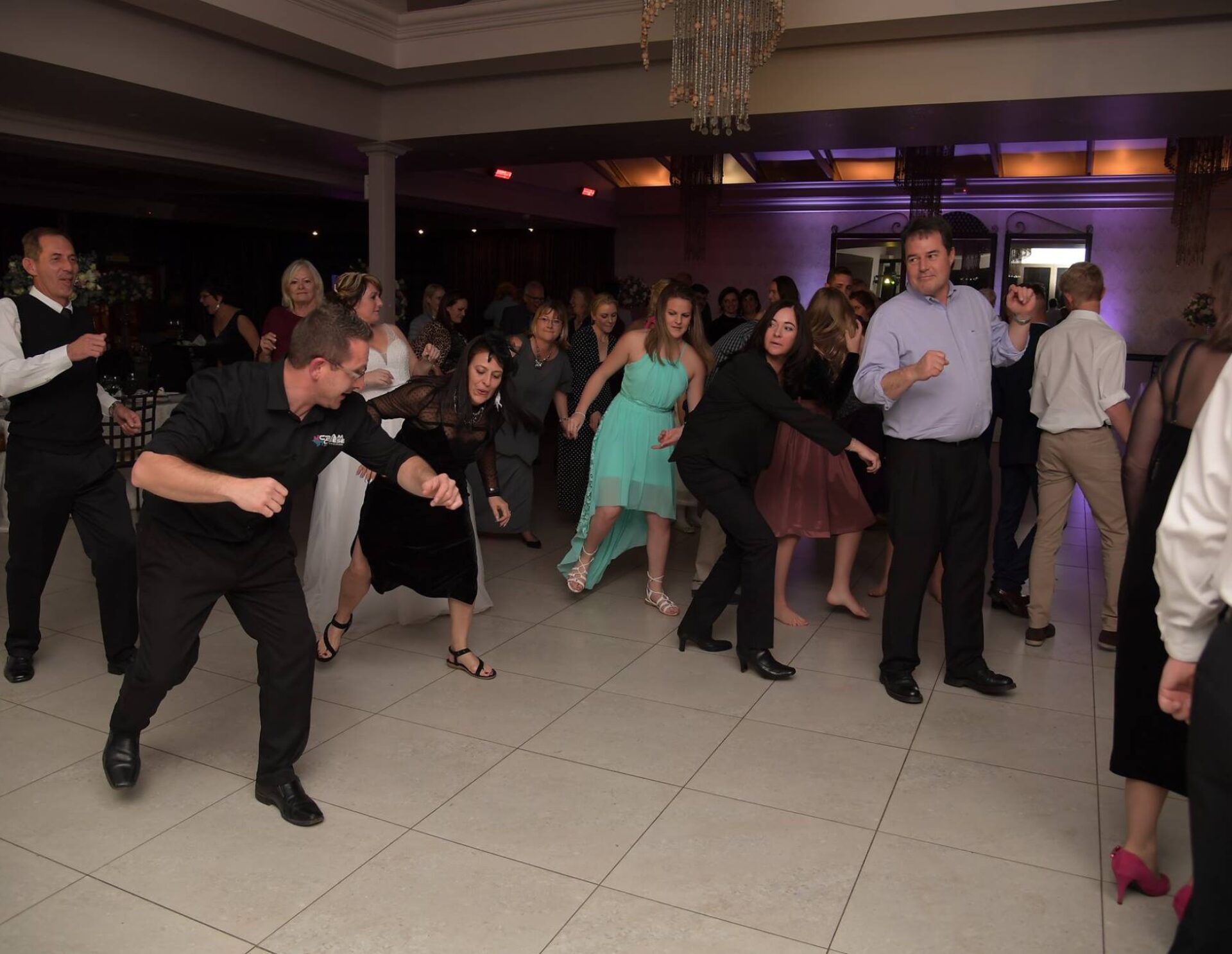 Guests dancing on a well-lit floor at an event.