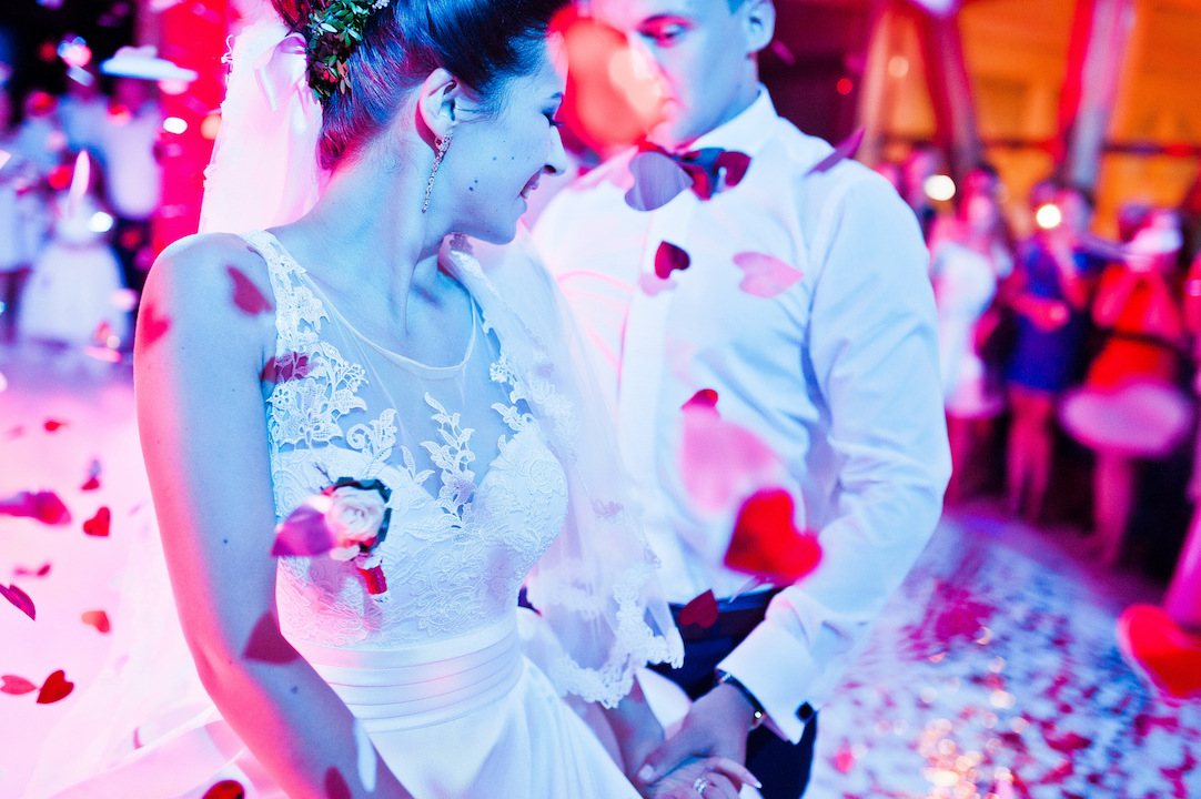 Couple dancing with rose petals falling around them.