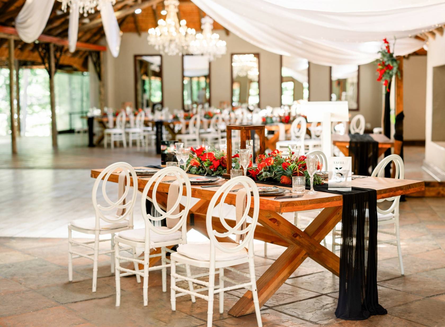 Decorative table with floral arrangements and black fabric in a venue