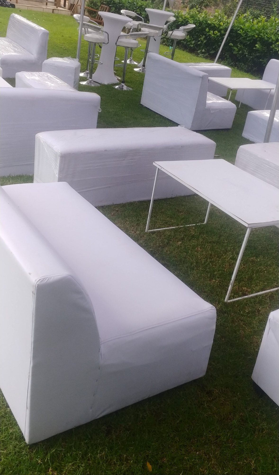 White lounge sofas and tables on green grass