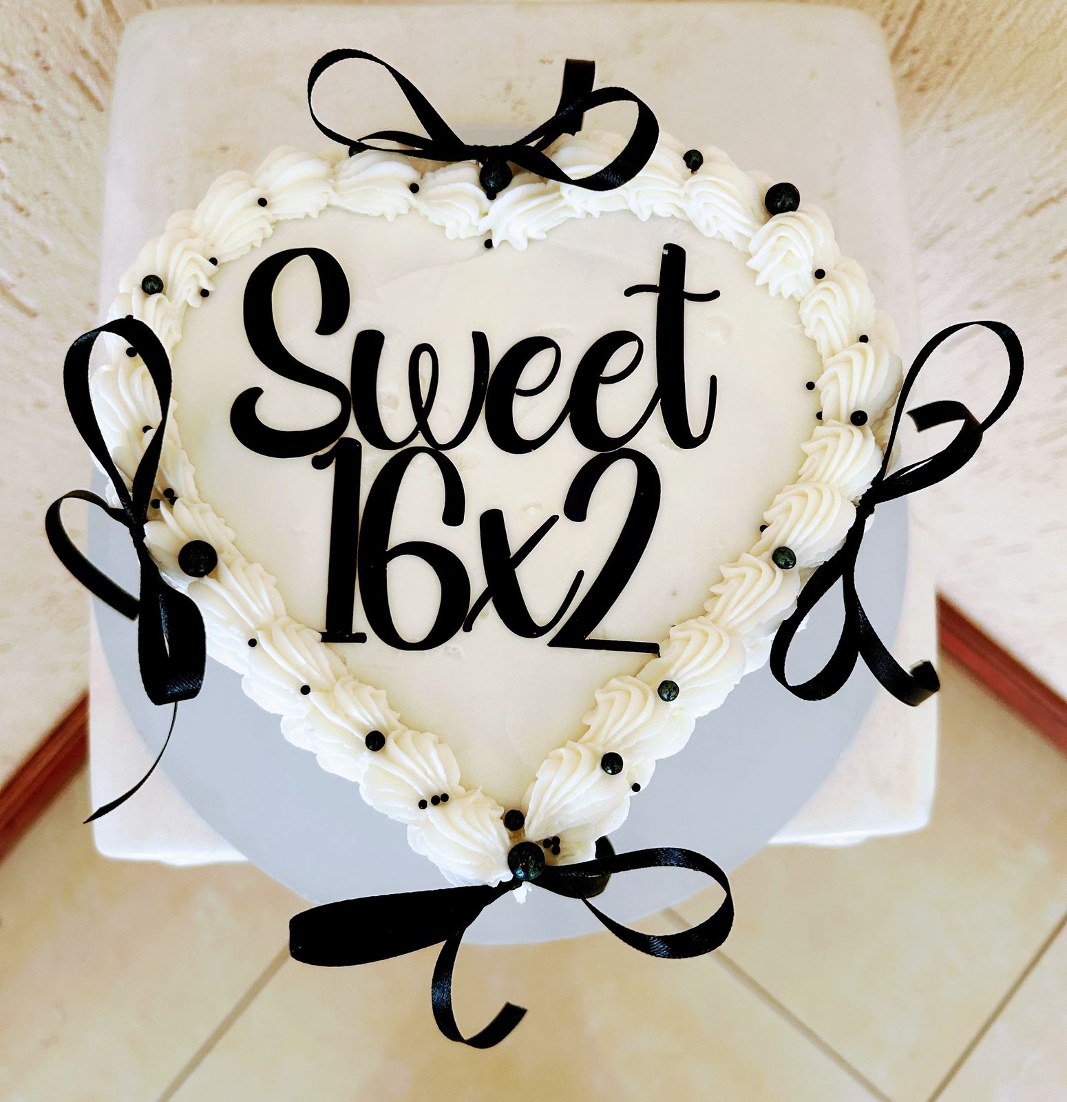 Heart-shaped cake with black ribbons and Sweet 16x2 decoration