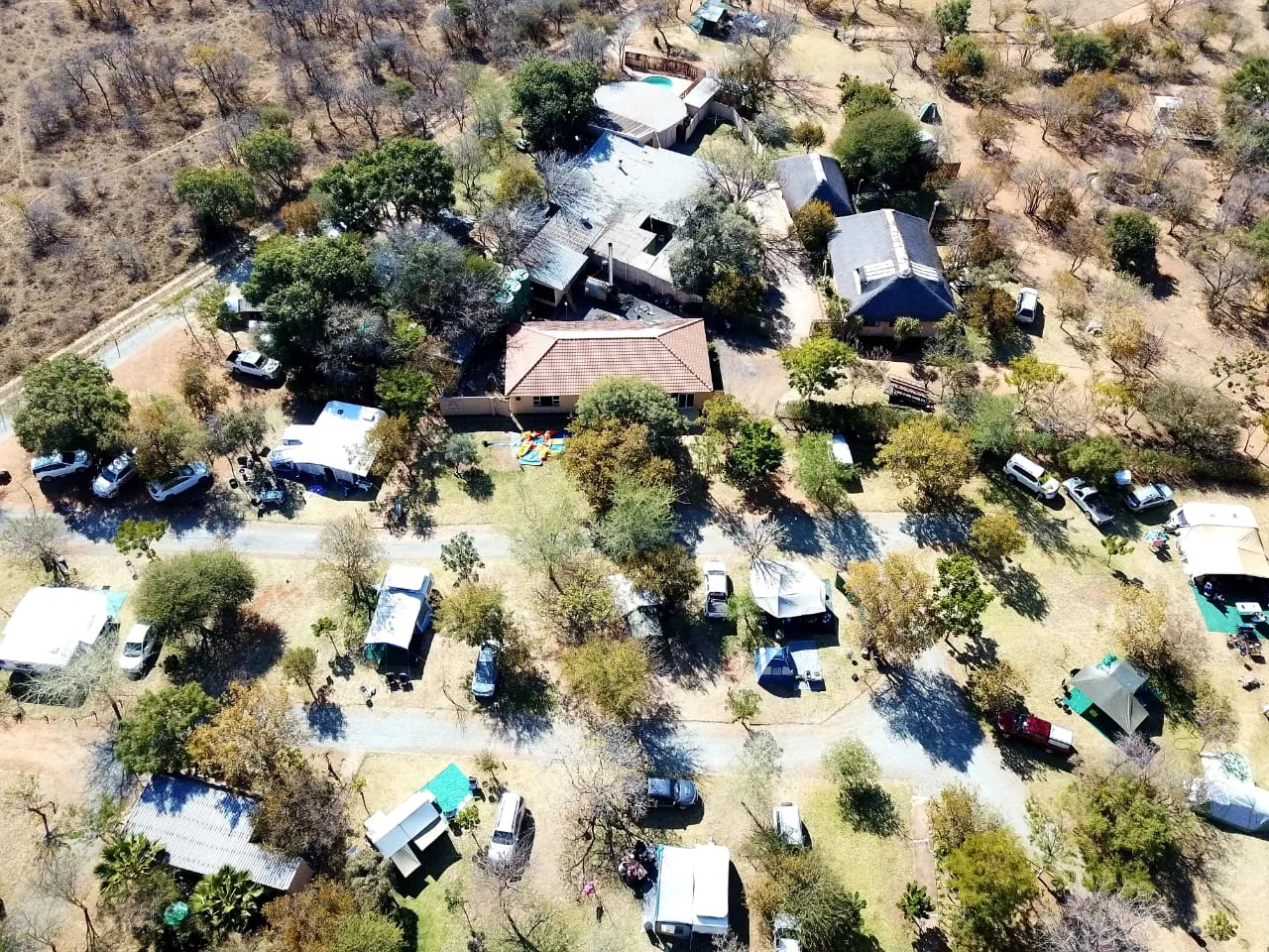 Aerial view of a camping venue with tents and vehicles