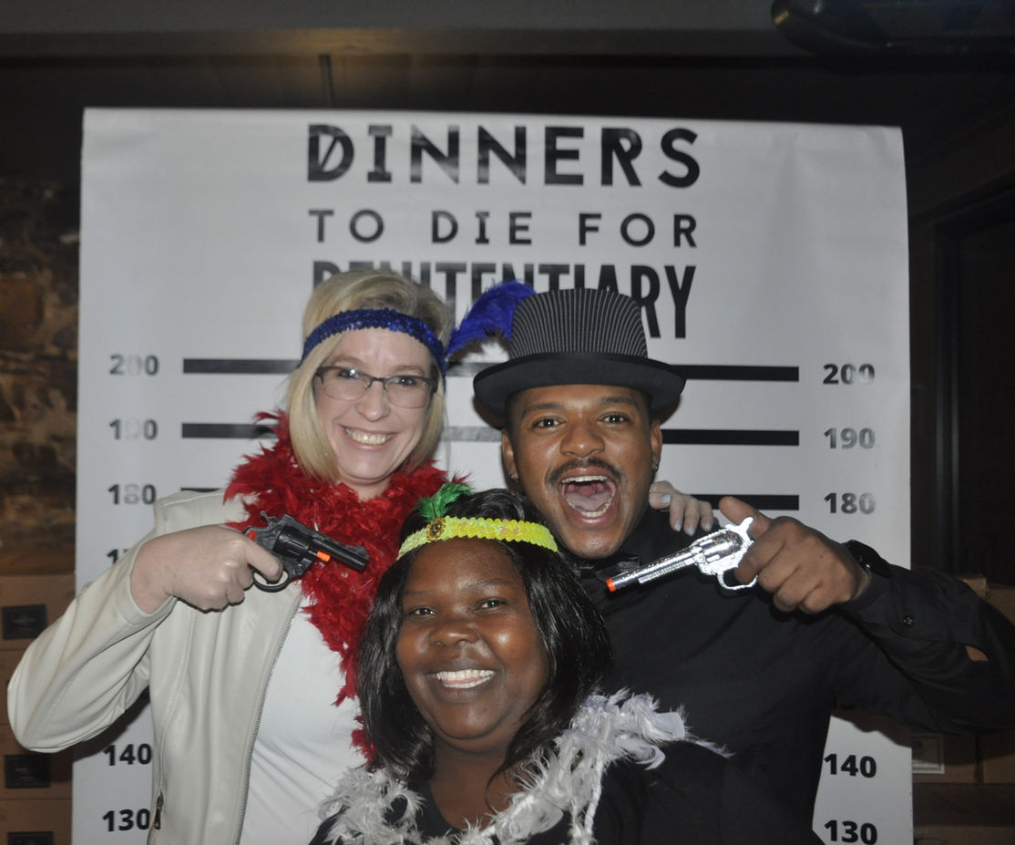 Participants in costume engaging in a murder mystery game