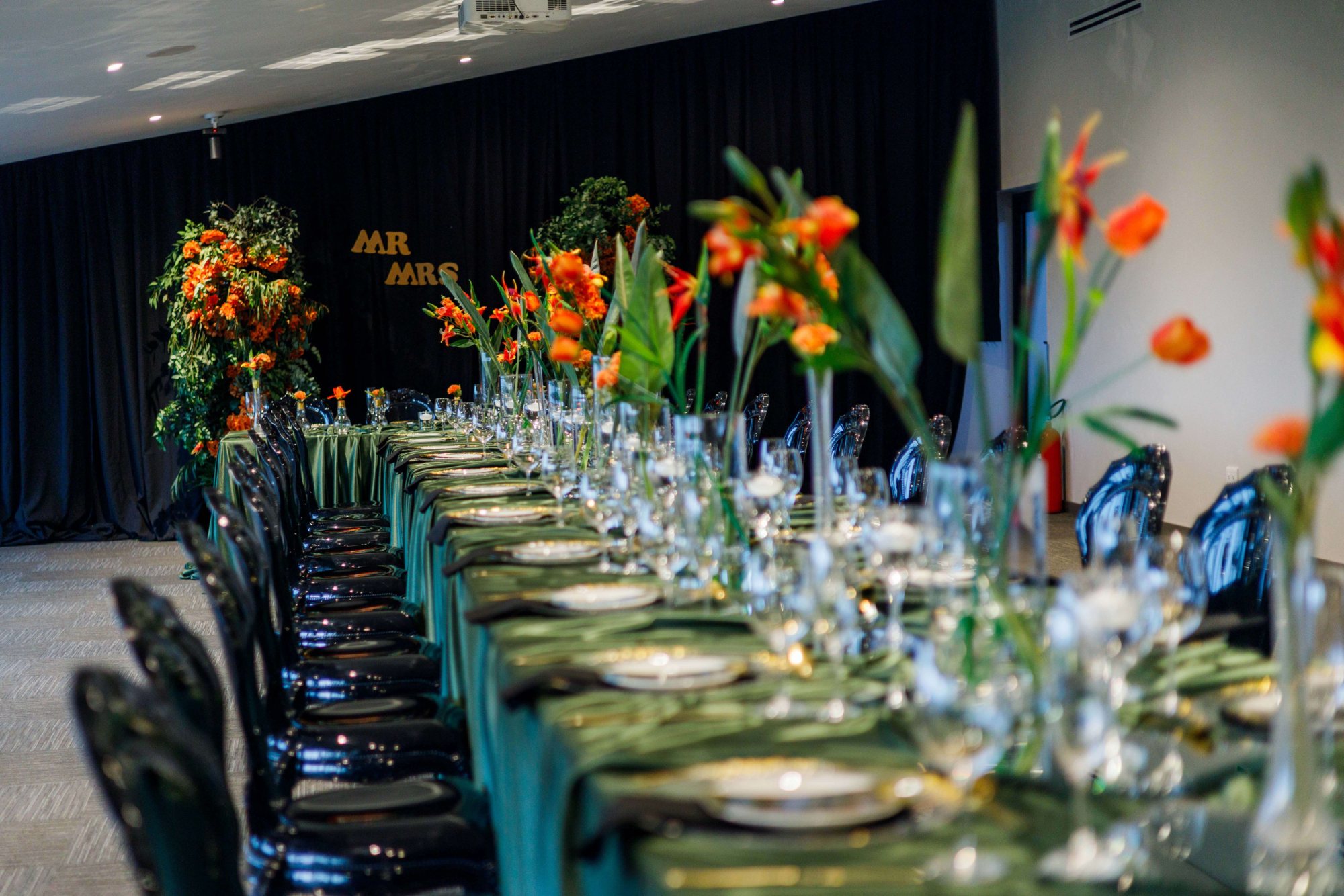 Long dining table with green linens and floral arrangements