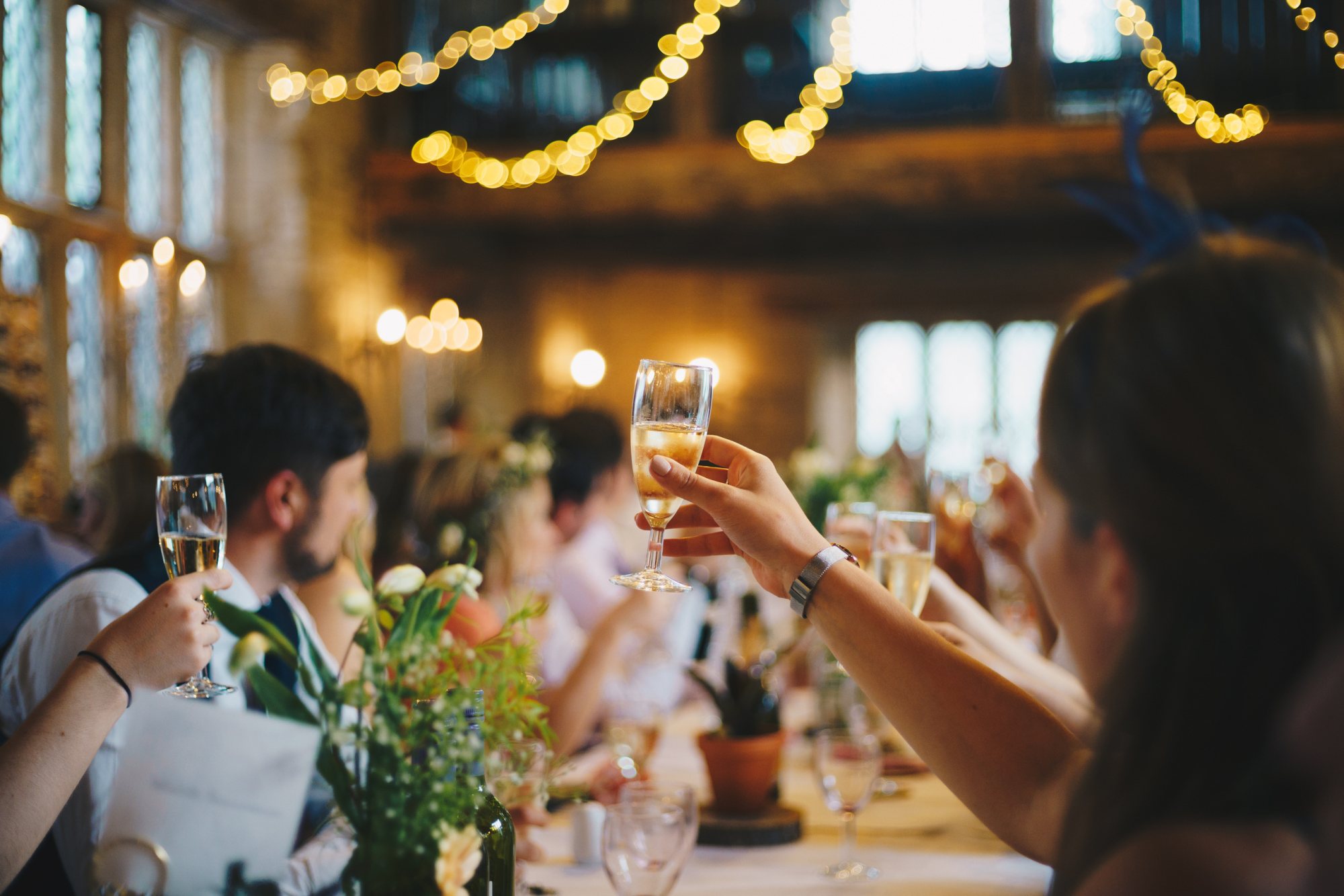 Guests toasting with champagne flutes at a festive table