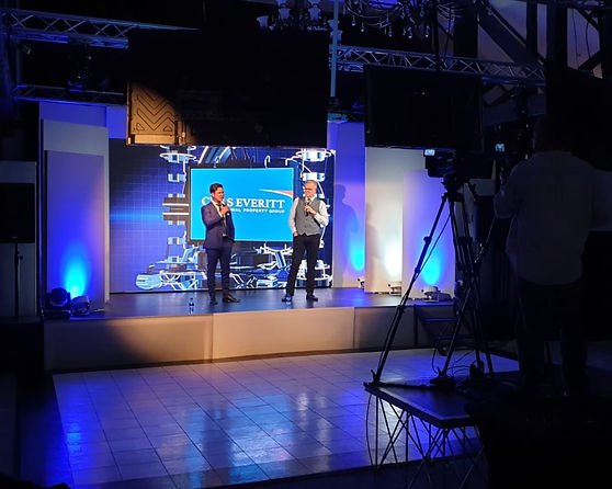 Stage setup with two presenters and a backdrop