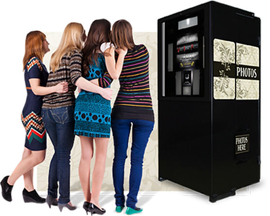 Group of women using a photo booth at an event.