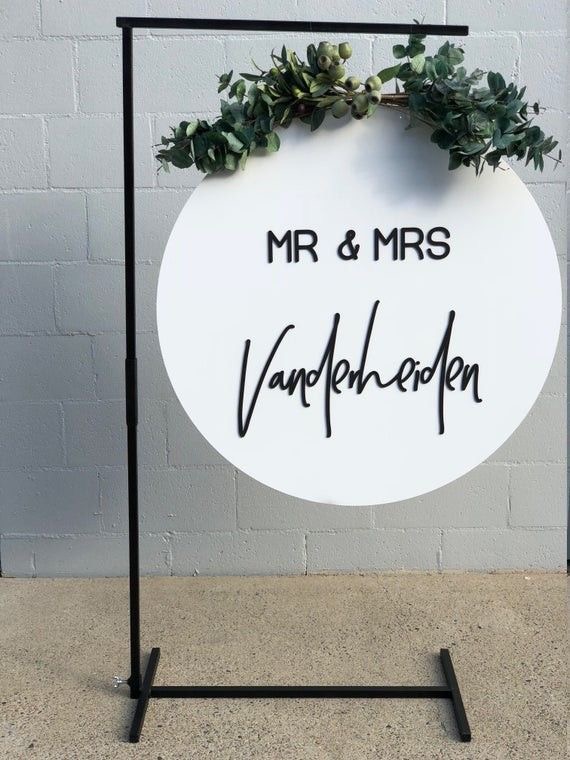 A circular welcome sign with 'Mr & Mrs Vanderlieden' in black lettering and greenery.