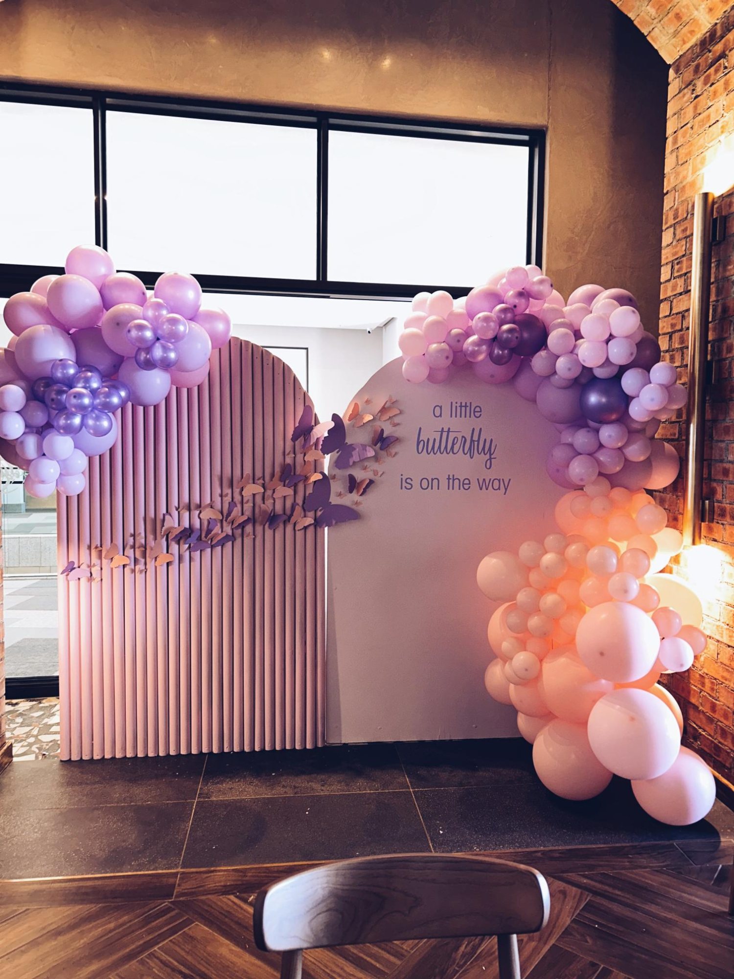 Butterfly-themed balloon installation in pastel colors