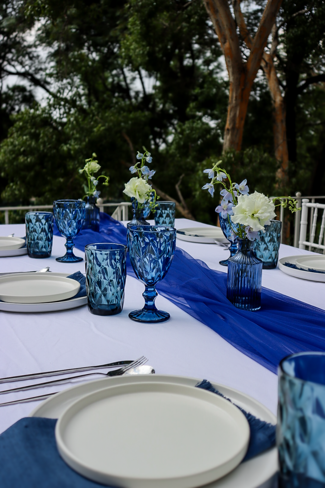 Blue glassware and floral accents on a table setting