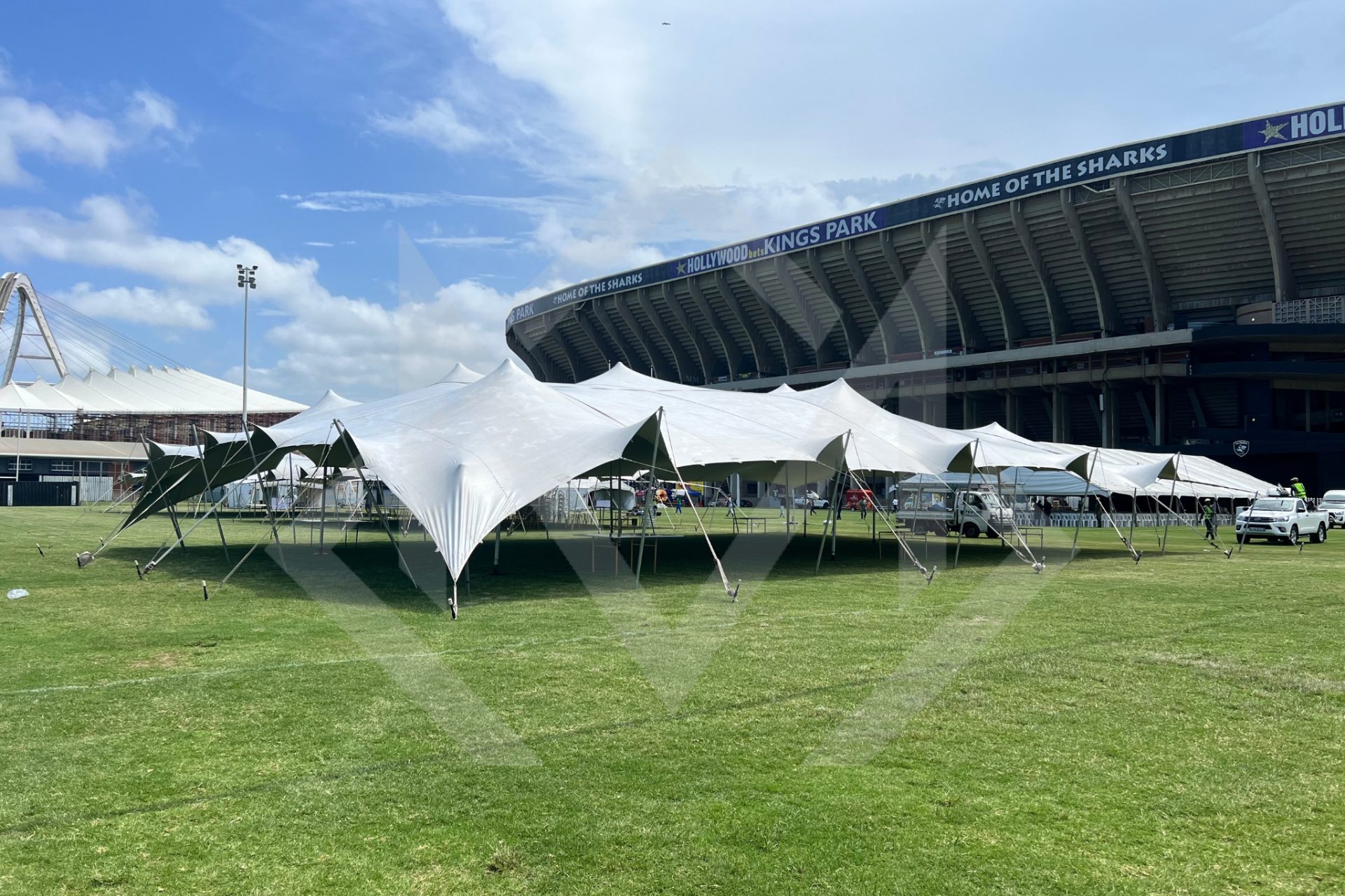 Large white stretch tent setup on grass at Kings Park Stadium.