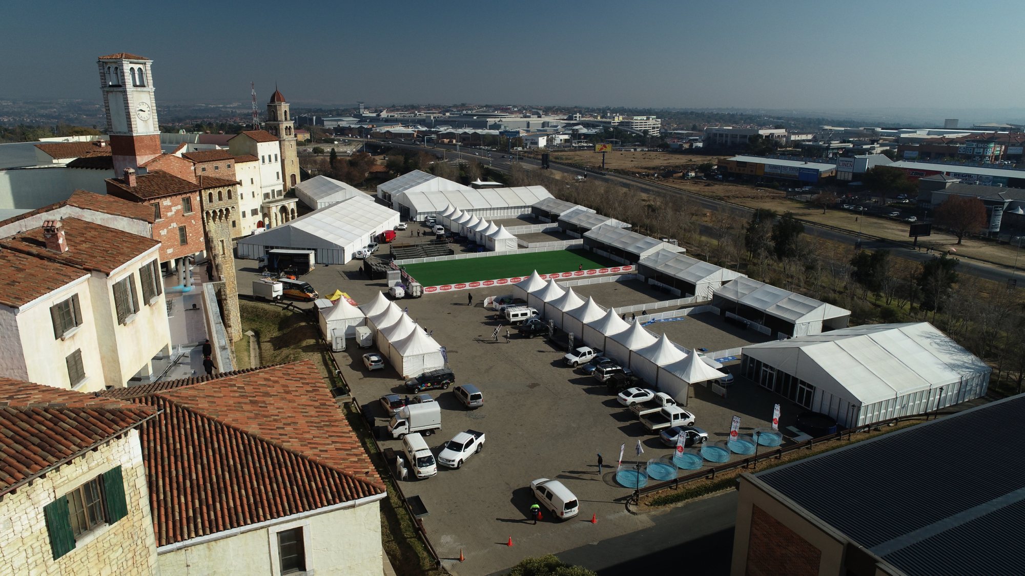 Aerial view of event tents and greenery setup in an outdoor venue.