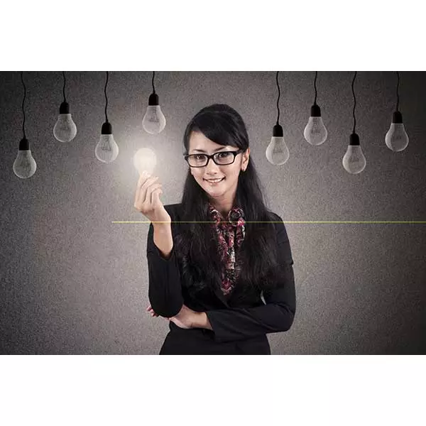 Woman holding a light bulb with hanging lights in the background