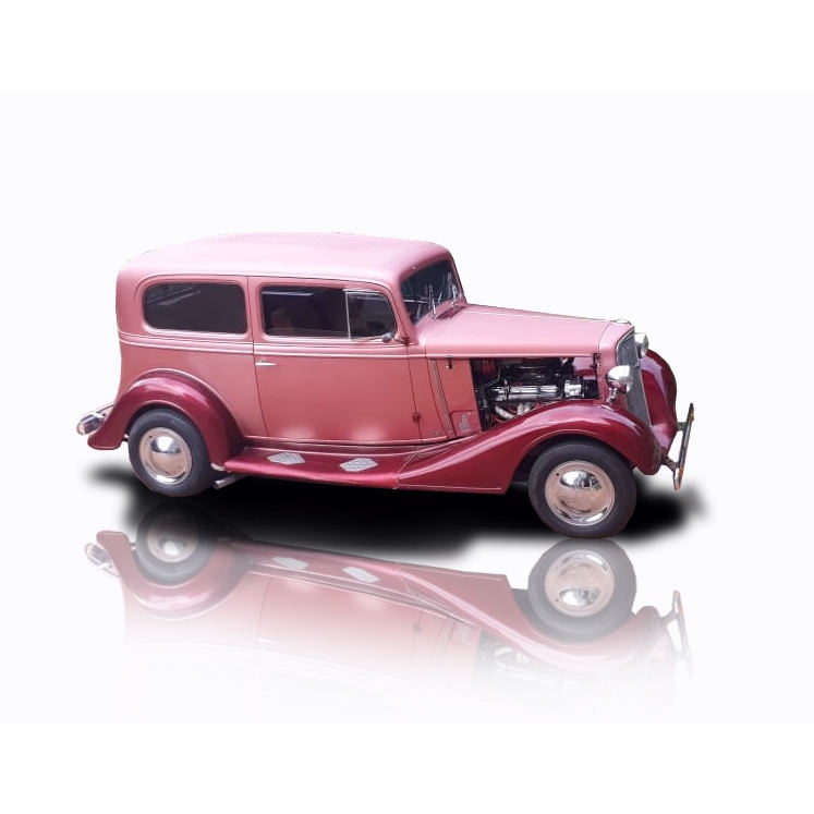Restored vintage car in pink with chrome details.