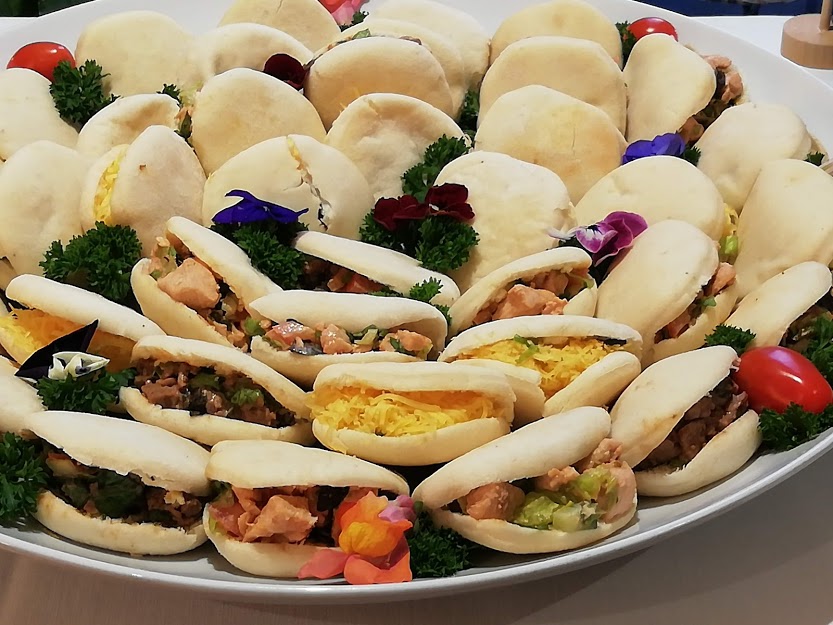 Platter of assorted finger snacks with filled buns and garnishes