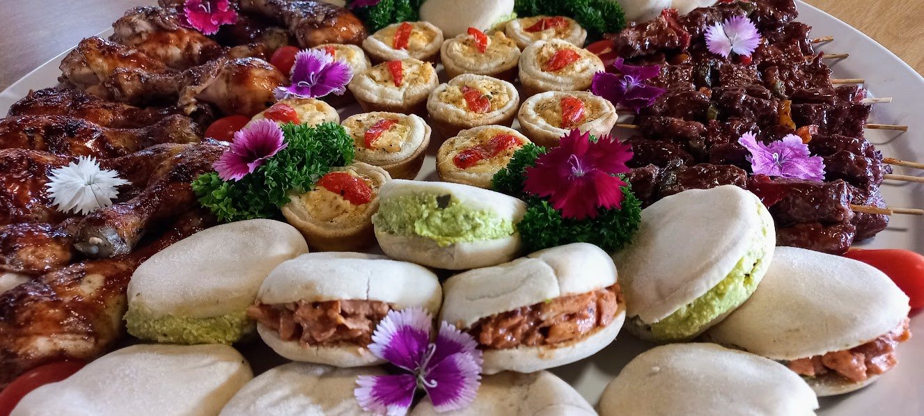 Colorful platter with finger snacks including sliders, canapés, and kebabs