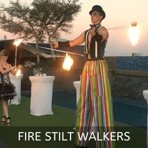 Fire stilt walkers performing with flames at an event