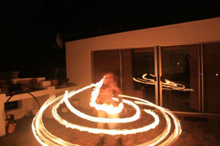 Fire performer creating swirling flames at night