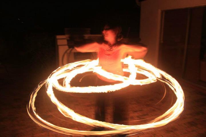 Fire poi performer spinning flaming poi in the dark