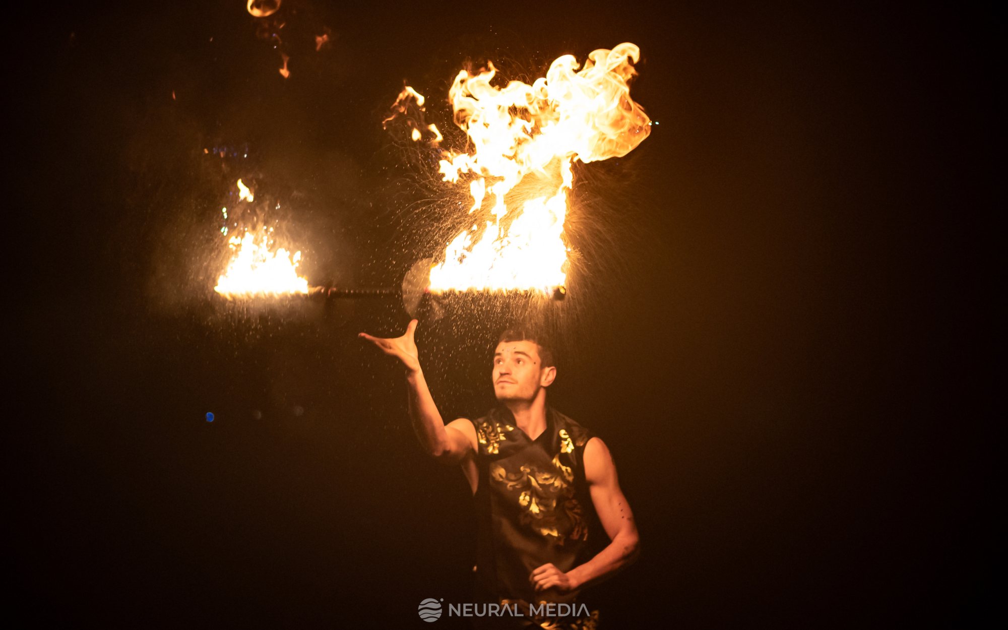 Performer juggling fire torches during a night show