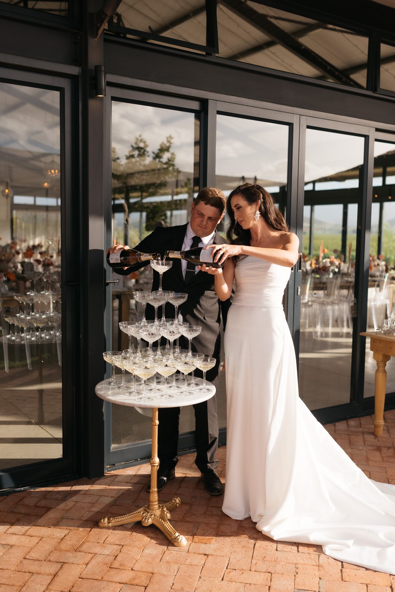 Couple pouring champagne into a tower of glasses