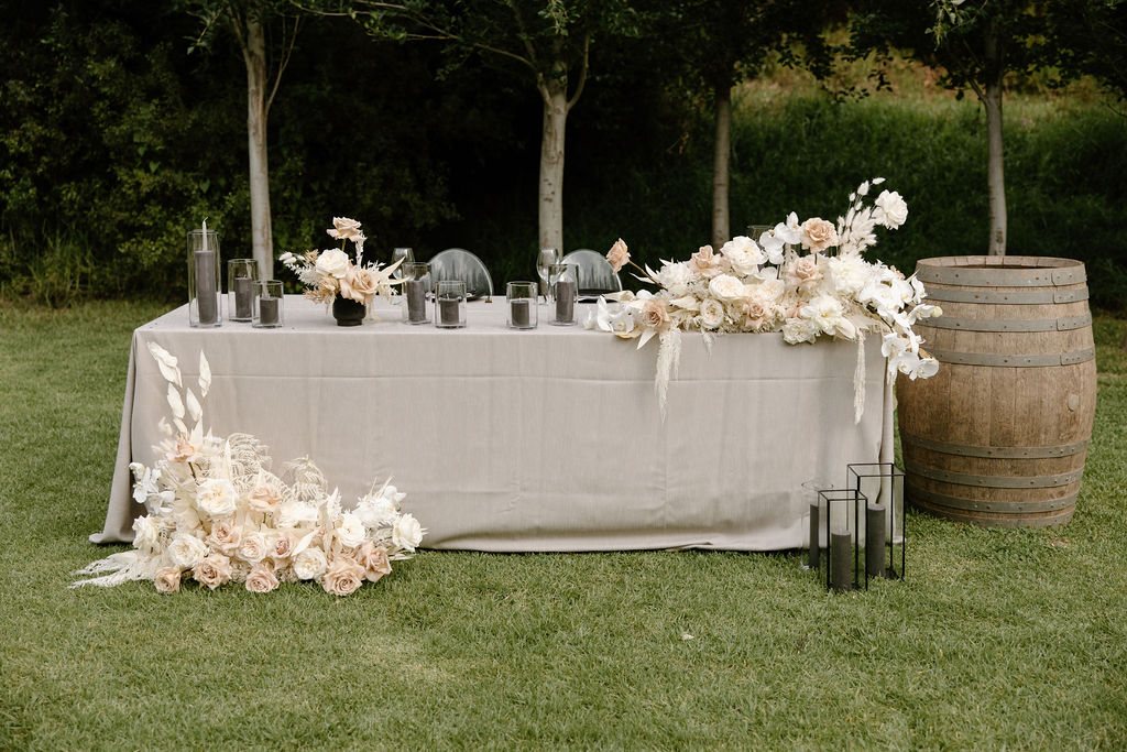 Cake table with floral arrangements and decorative vases
