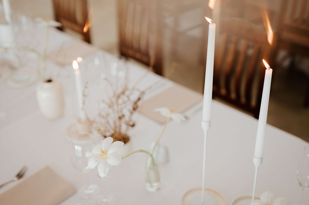 Elegant table setting with white candles and flowers