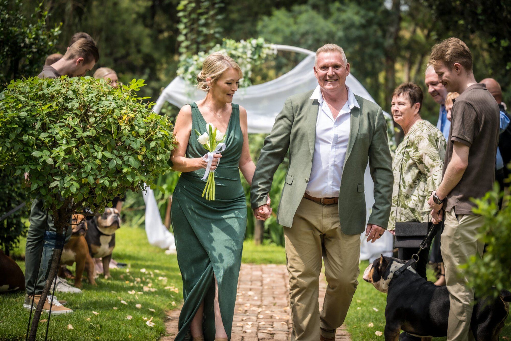 Couple walking down the aisle in a garden setting during a wedding
