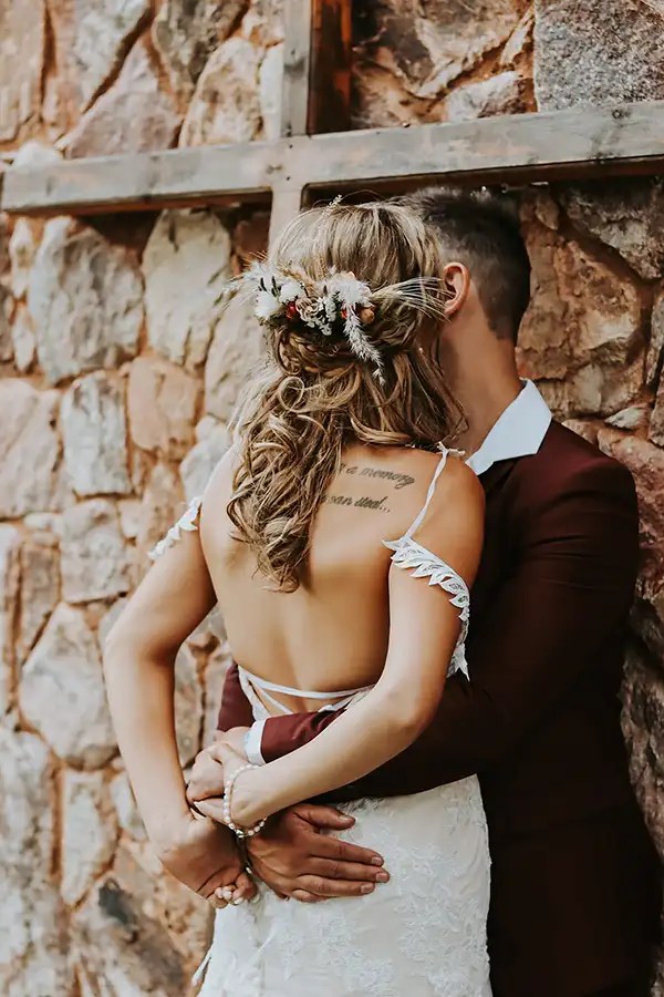 Couple embracing with a backdrop of stone wall