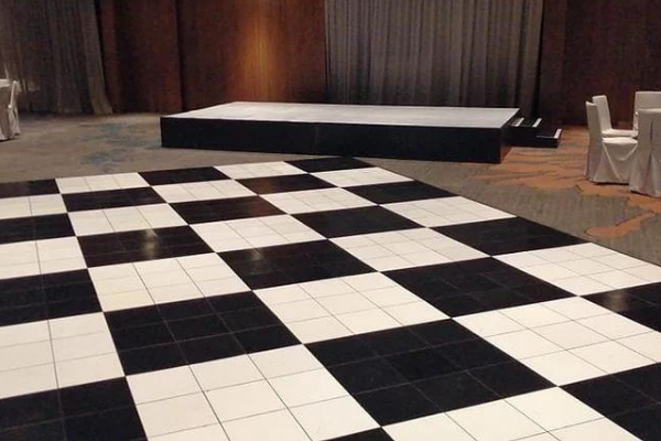 Black and white checkerboard dance floor with a stage