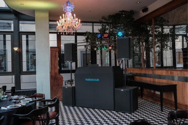 DJ booth with sound equipment and colorful lights in a venue