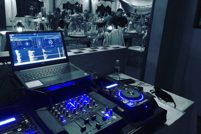 DJ setup with laptop and mixers at an event