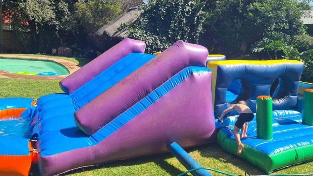 Inflatable water slide with a child playing nearby