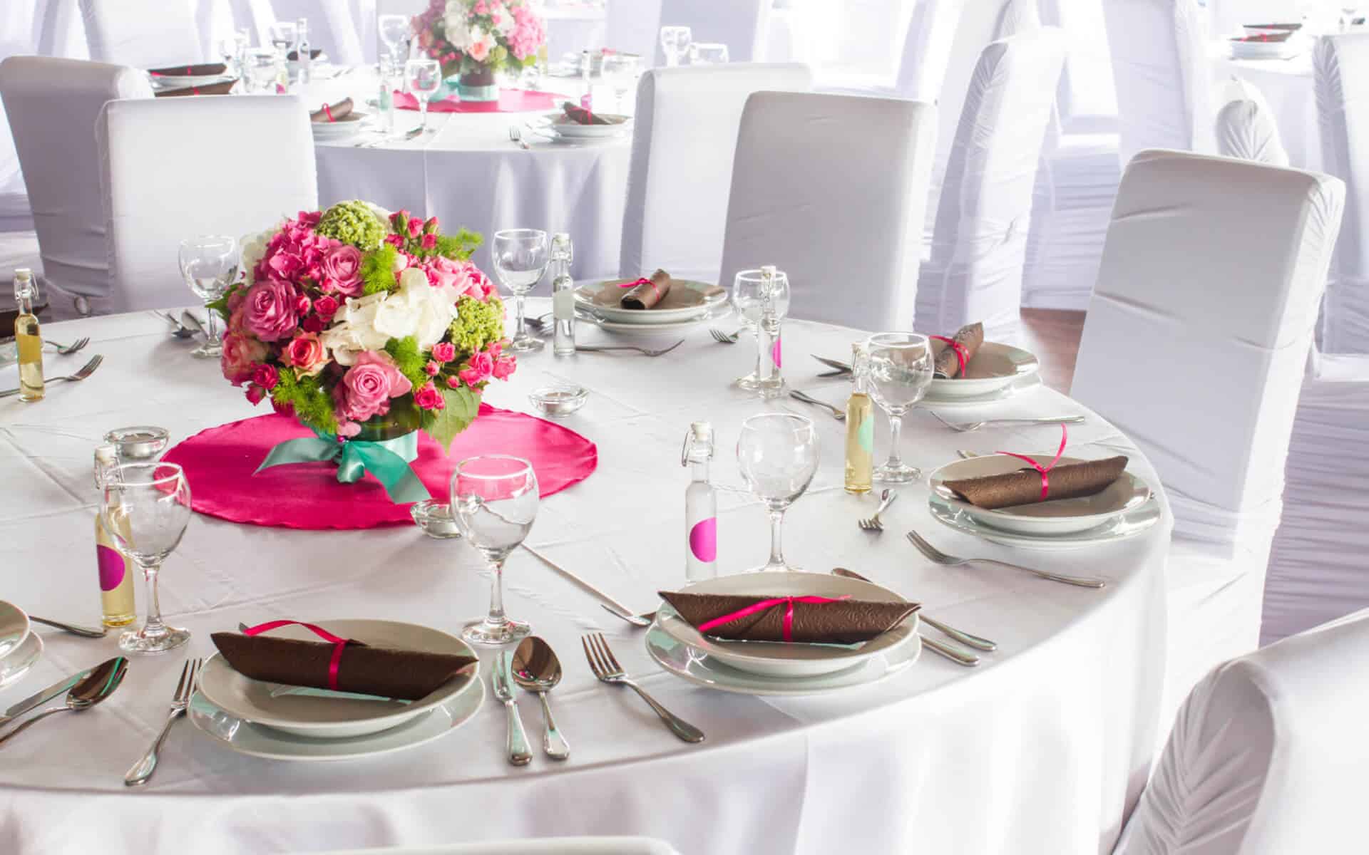 Table set with white linens, floral centerpiece, and elegant dishware.