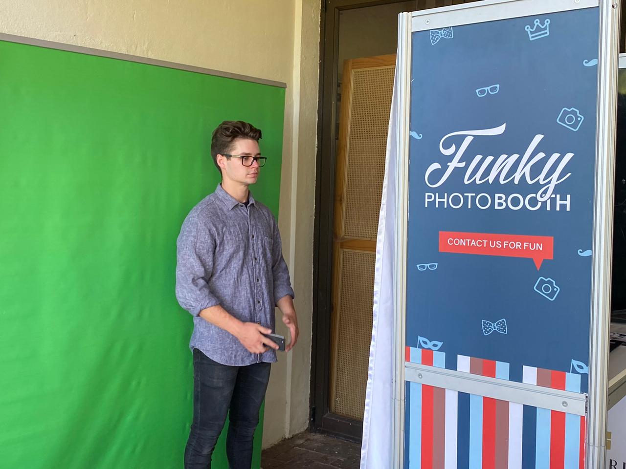 Man next to Funky Photo Booth with green screen