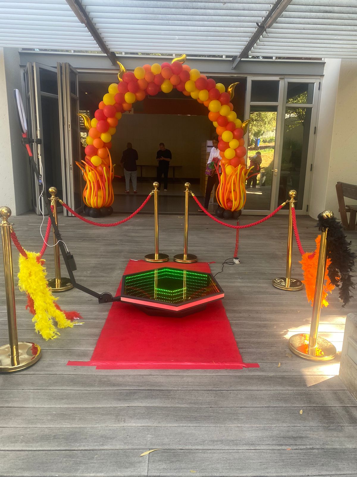 Colorful balloon arch and red carpet for a 360 booth.