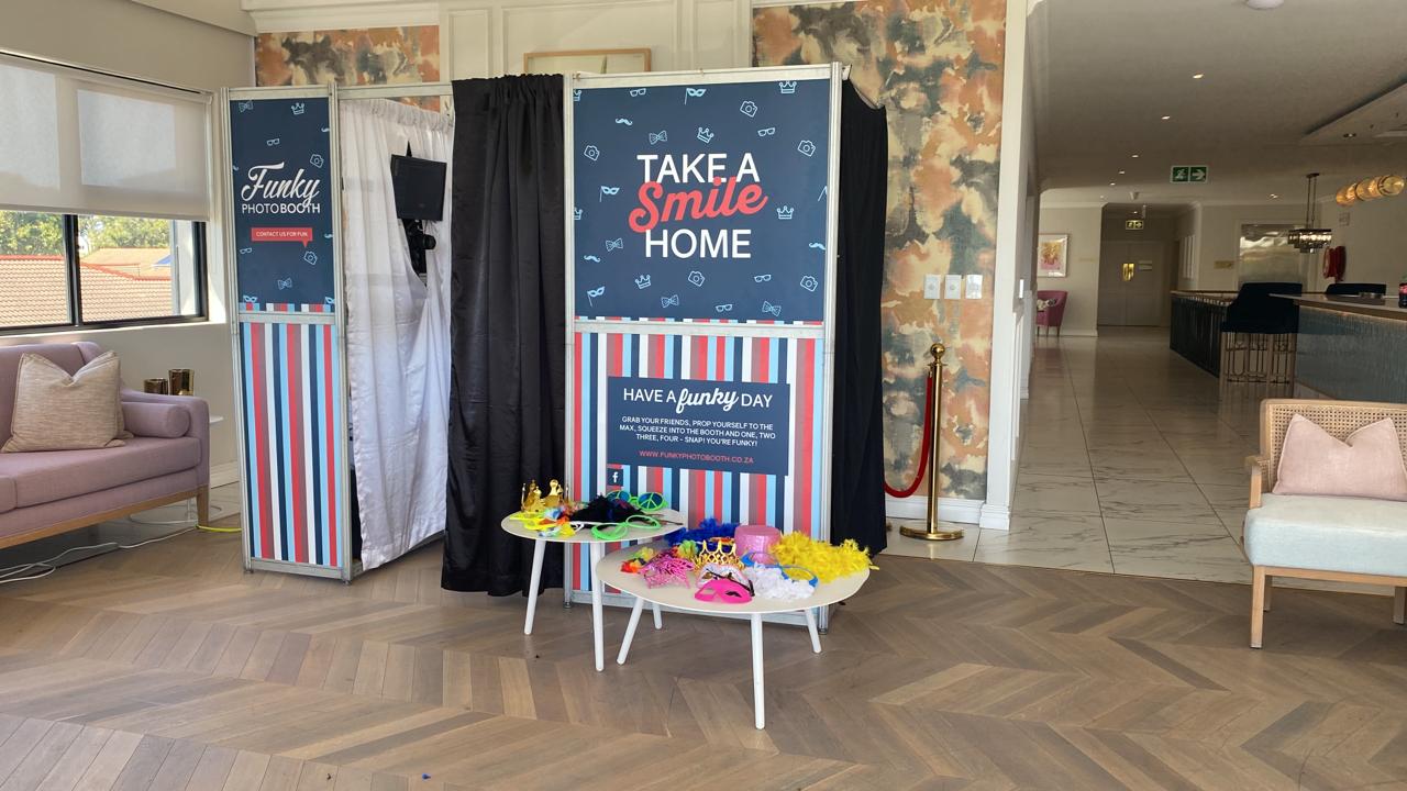 Interactive photo booth with props and backdrop in venue
