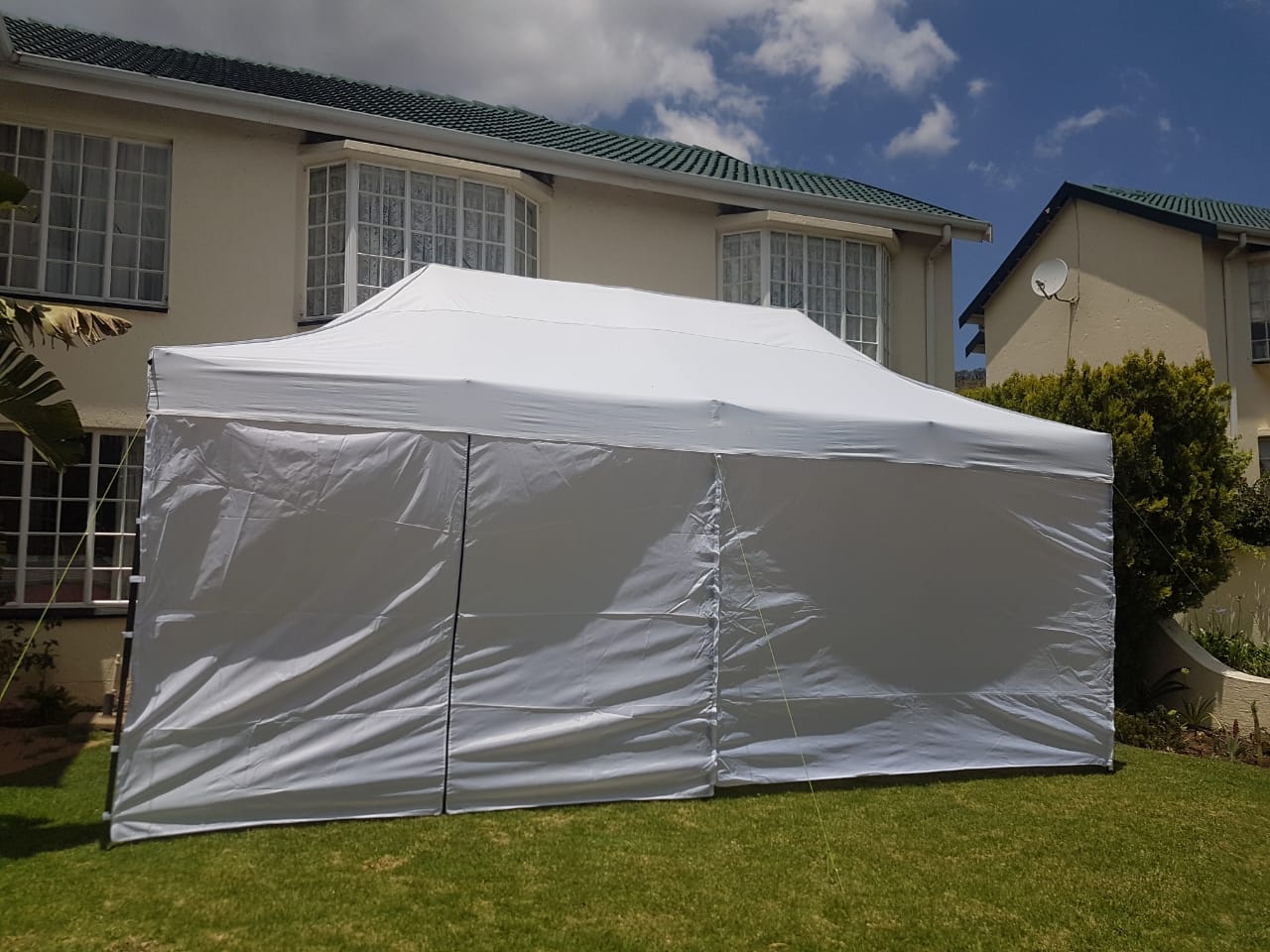 White gazebo set up on a lawn.