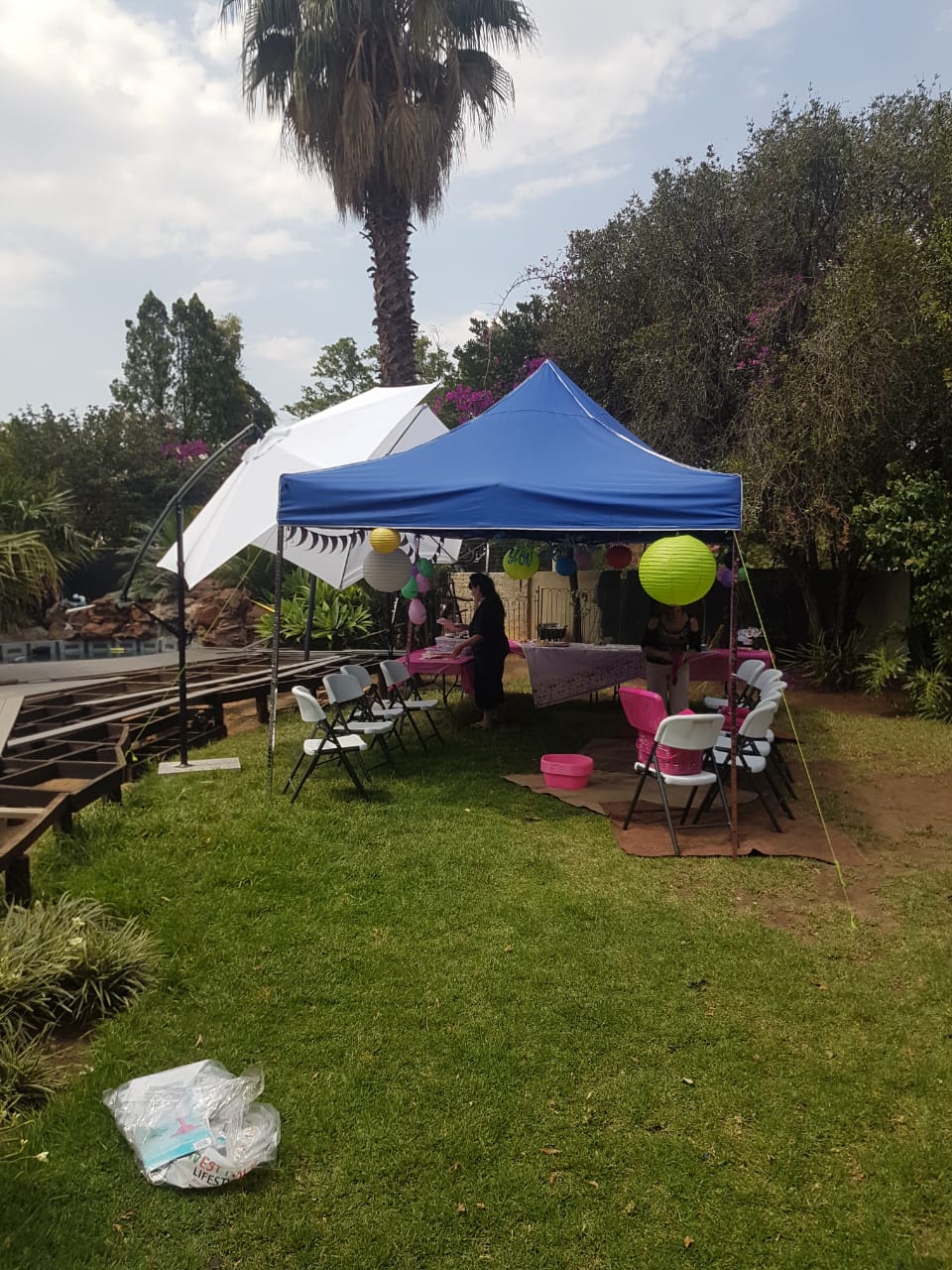 A blue gazebo with tables and decorations for a party setup