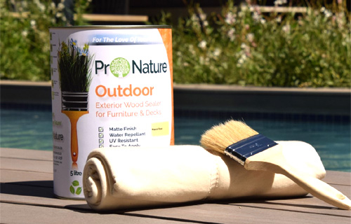 Can of outdoor wood sealer with a brush on a wooden surface
